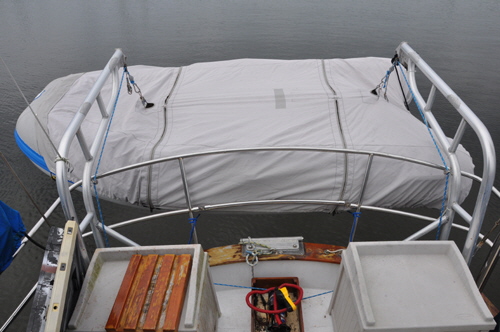 The dinghy hings from the davits and the zips give easy access for stowage of fenders and lines.