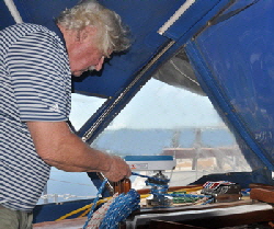 Furling the square sail from the cockpit.