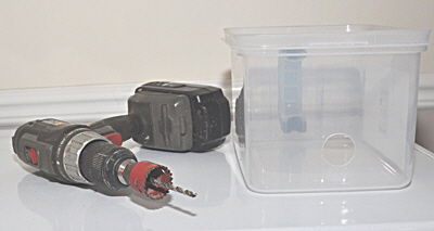 A hole cutter is used to drill the two holes for the inlet and outlet pipes.